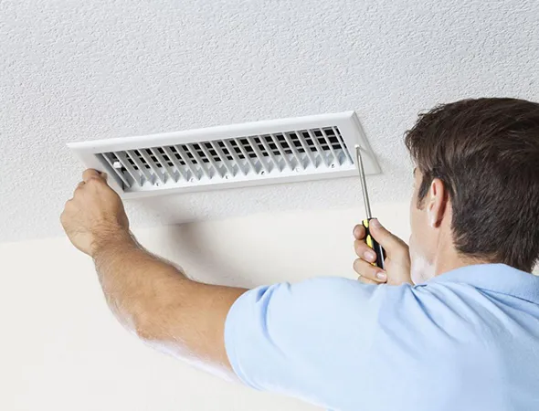 Expert removing dust and allergens from air ducts in a Lakeland, TN home using safe and effective tools.