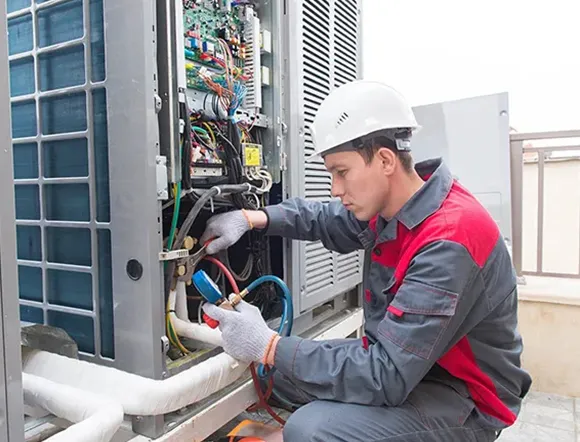 Preventative HVAC service technician in Memphis examining filters and wiring for early issue detection.